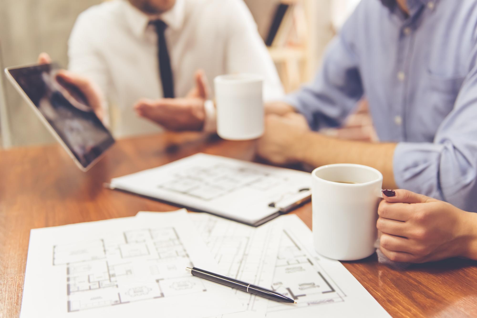 consultanță imobiliară la birou cu planuri pe masă